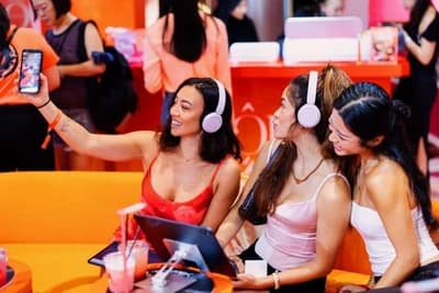 Guests wearing headphones share their Idôle House experience at the Lancôme pop-up